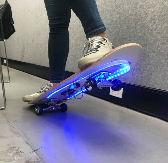 PILOT SK.8 design of skateboard lined with blue LED lights on the bottom.